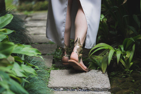 Woman wearing wedding shoes golden colored with angel's wings