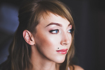 Fototapeta premium Close portrait of a bride with ready make-up, piercing and stylish hairstyle