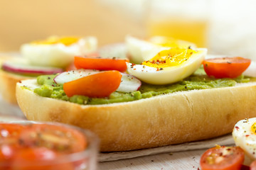 Avocado toast with soft boild eggs and cherry tomato slices