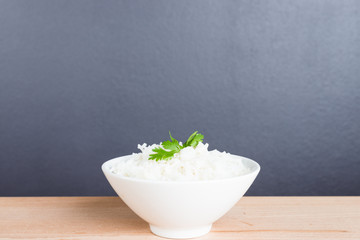 Steamed rice on white bowl wood background