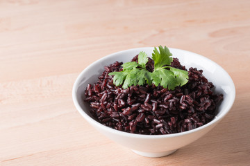 Steamed rice on white bowl wood background