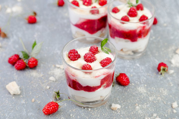 Tiramisu with raspberry in glasses on grey background. Three portion. Italian dessert