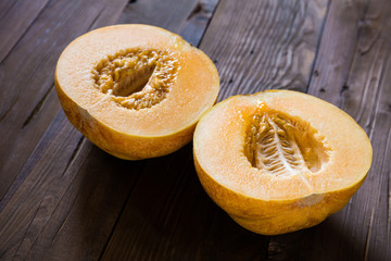 Melon cut in half on a wooden background