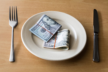 Plate full of money with fork and knife, Business concept.