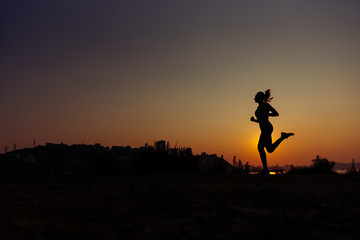 The woman does exercises at sunrise.