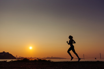 The woman does exercises at sunrise.