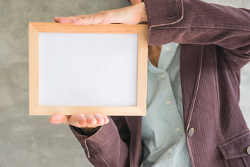 Blank wooden photo Frame in the woman's hand .