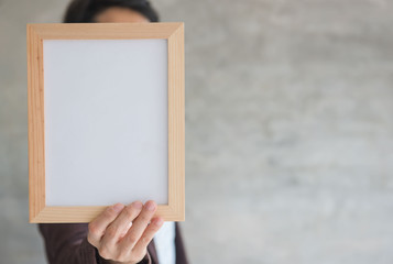 Blank wooden photo Frame in the woman's hand .