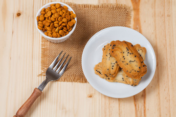 Home made a small sweet cookie with black sesame, typically round, flat, and crisp.Cookie in dish on wood.