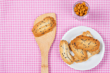 Home made a small sweet cookie with black sesame, typically round, flat, and crisp.Cookie in dish on tablecloth.
