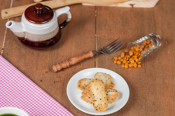 Hand hold a home made a small sweet cookie with black sesame.