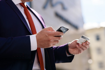 Man works with credit card and telephone.