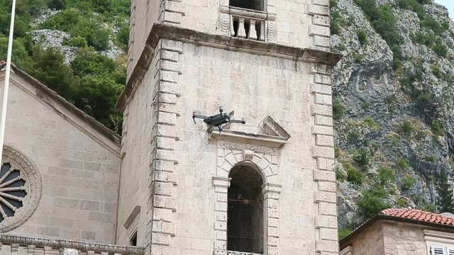 Flying drone shooting old town Kotor Montenegro. Aerial view shot from copter drone. Saint Michael Church Kotor. Drone in sky aerial shot.