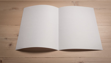 White blank paper notepad on wooden table.