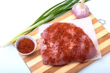 pork steaks with fat. Meat is on wooden board with spice as pepper and green spring onion. Ready for cooking. Selective focus.