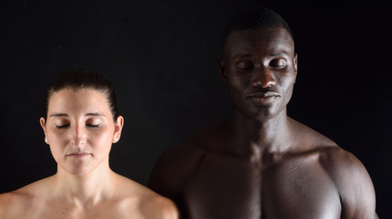portrait of a mixed couple with eyes closed on black