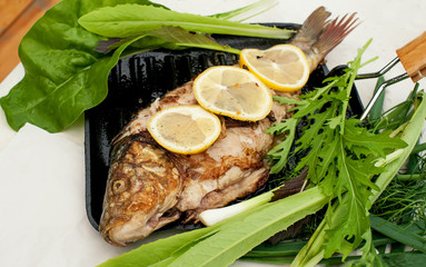 Grilled carp marinated in lemon and spices with green leaf lettuce .