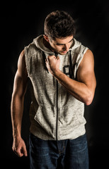 Fototapeta na wymiar Young fit man flexing his bicep isolated on black background