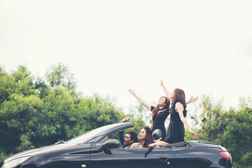 Fototapeta na wymiar Happy teenage friends having fun sit on car along country road.