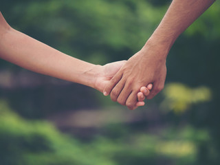 Image of couple holding hands together.