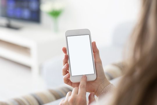 Female hands holding phone with isolated screen in  room
