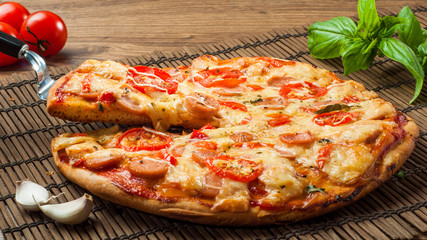 Hot pizza slice with melting cheese on a rustic wooden table