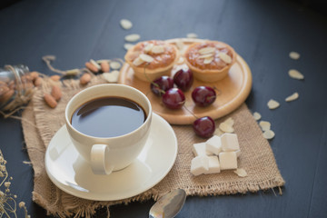 Coffee drink breakfast concept. Includes crispy tarts with almond, Waffles and fresh cherry