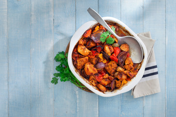 Baked chicken breast with vegetables on blue rustic wooden table