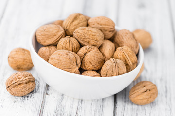 Portion of Whole Walnuts on wooden background (selective focus)