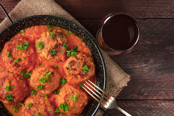 Pan of meatballs in tomato sauce, overhead photo with copyspace