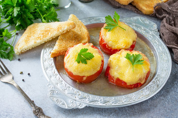 Stuffed tomatoes. Tomatoes baked with cheese and chicken, served with croutons of white bread.