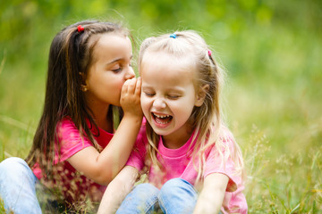 The young girls plays with a racket in badminton over green grass