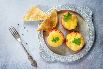 Stuffed tomatoes. Tomatoes baked with cheese and chicken, served with croutons of white bread. Top view.