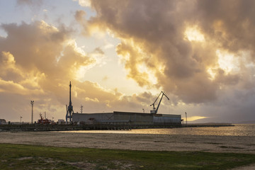 Fototapeta na wymiar Commercial harbor at stormy sunset
