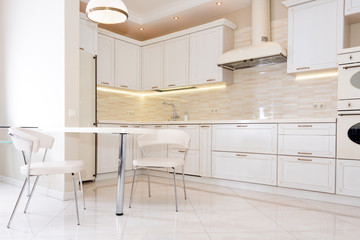 Modern, bright, clean kitchen interior in a luxury house. Interior design with classic or vintage elements. Practical and well-furnished kitchen.