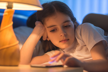 The cute girl phone in the bed. night time