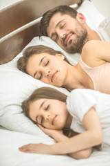 The family sleeping on the comfortable bed