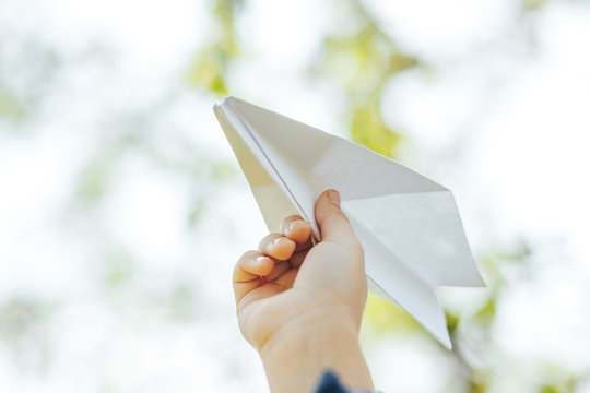 the plane of the paper in the hands of the child and the blue sky