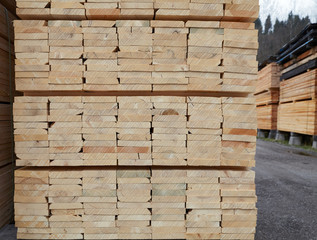 Pattern of stacked rectangular wooden beam timber at sawmill lumberyard
