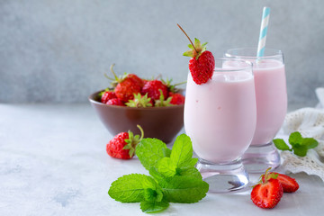 Freshly squeezed strawberry berry cocktail in a glass jar on a gray stone or slate background. Superfoods and health or detox diet nutrition concept. Copy space.