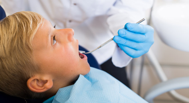 Adult doctor in uniform is taking visional inspection of a child