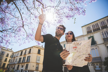 Tourist couple standing outside holding map