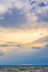 bird flying over surface of green sea waves with mountains on background
