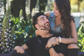 Happy couple sitting outside embracing together