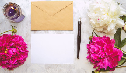 Vintage mockup. Blank paper and envelope, candle, pink and white peonies, pen. Wedding invitation