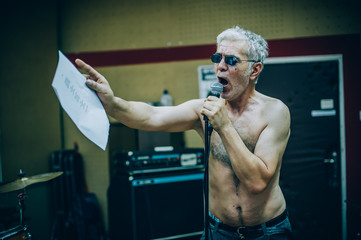 Behind scene. Famous alternative male singer practice singing on microphone