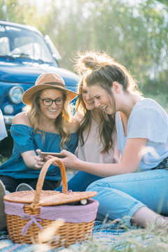 Friends having picnic looking at smartphone smiling, Firenze, Toscana, Italy, Europe