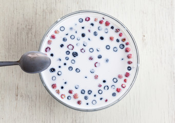 Summer berries with milk on wooden background 