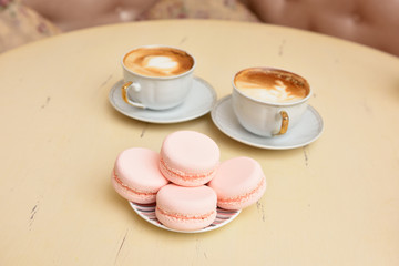 Macaroons and two cups of coffee on a vintage table