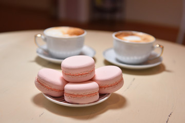 Obraz na płótnie Canvas Macaroons and two cups of coffee on a vintage table